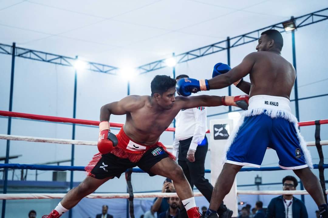 Two boxers exchanging in a floodlit ring