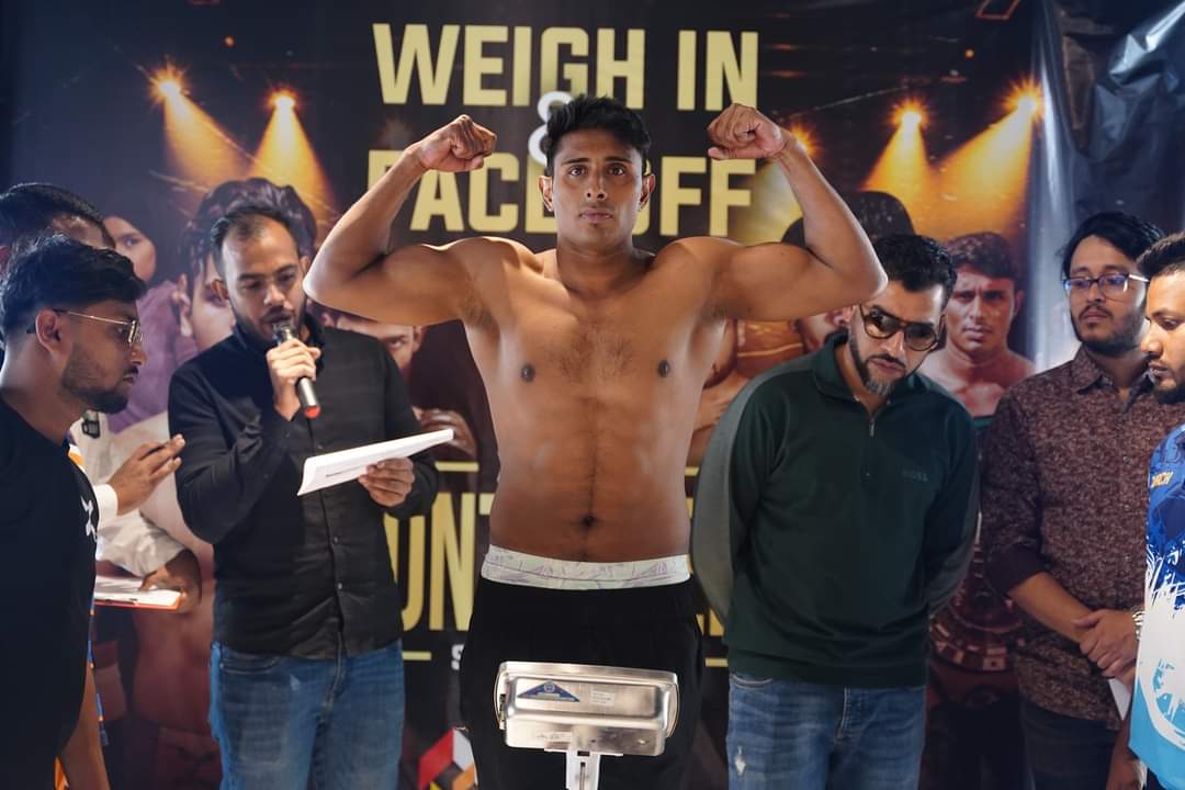A boxer flexing on stage at a weigh-in and face-off