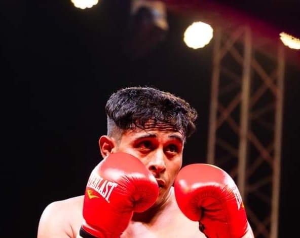 A boxer in red gloves under the ring lights