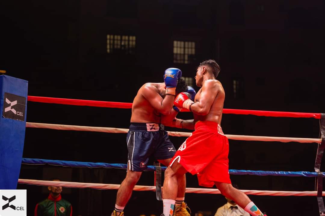 A boxer in red shorts in an exchange in an indoor ring