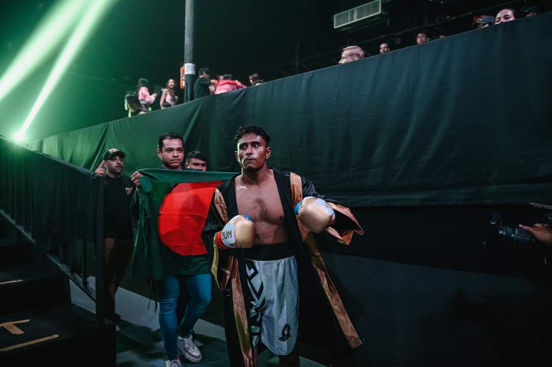 Al-Amin in his robe walking to the ring past the Bangladesh flag