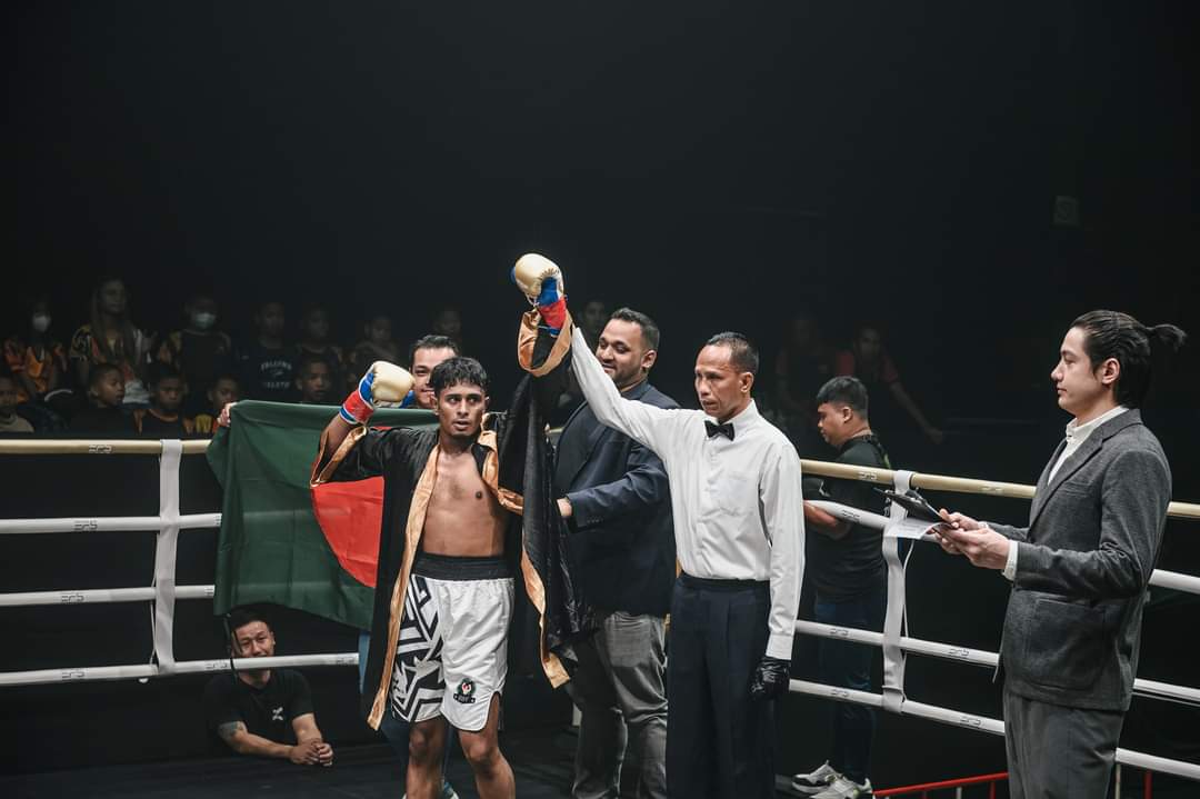 Al-Amin's hand raised after a bout, the Bangladesh flag held up at ringside