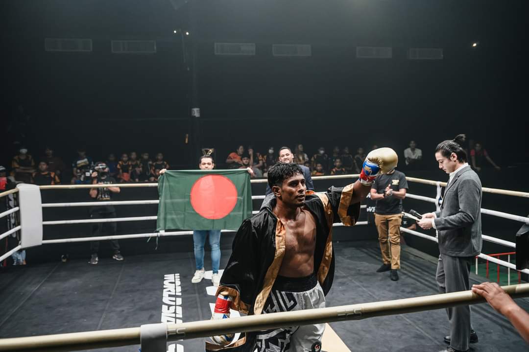 Al-Amin at the ropes in his robe, the Bangladesh flag behind