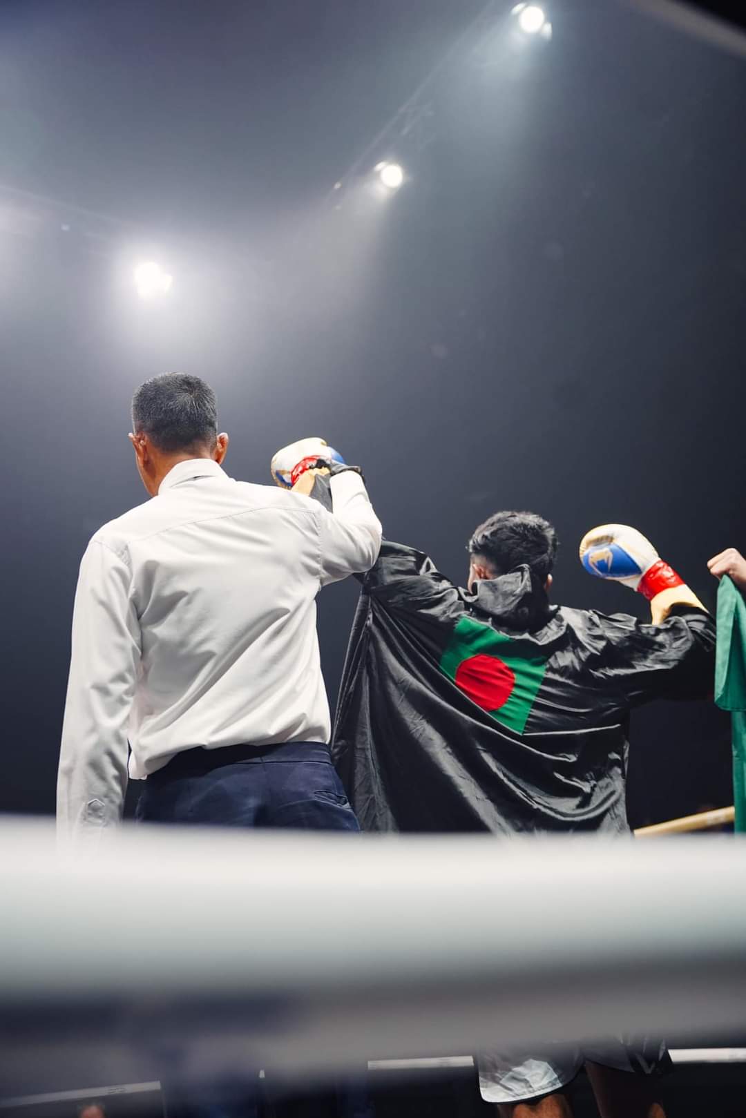 The referee raises Al-Amin's hand, the Bangladesh flag over his shoulders