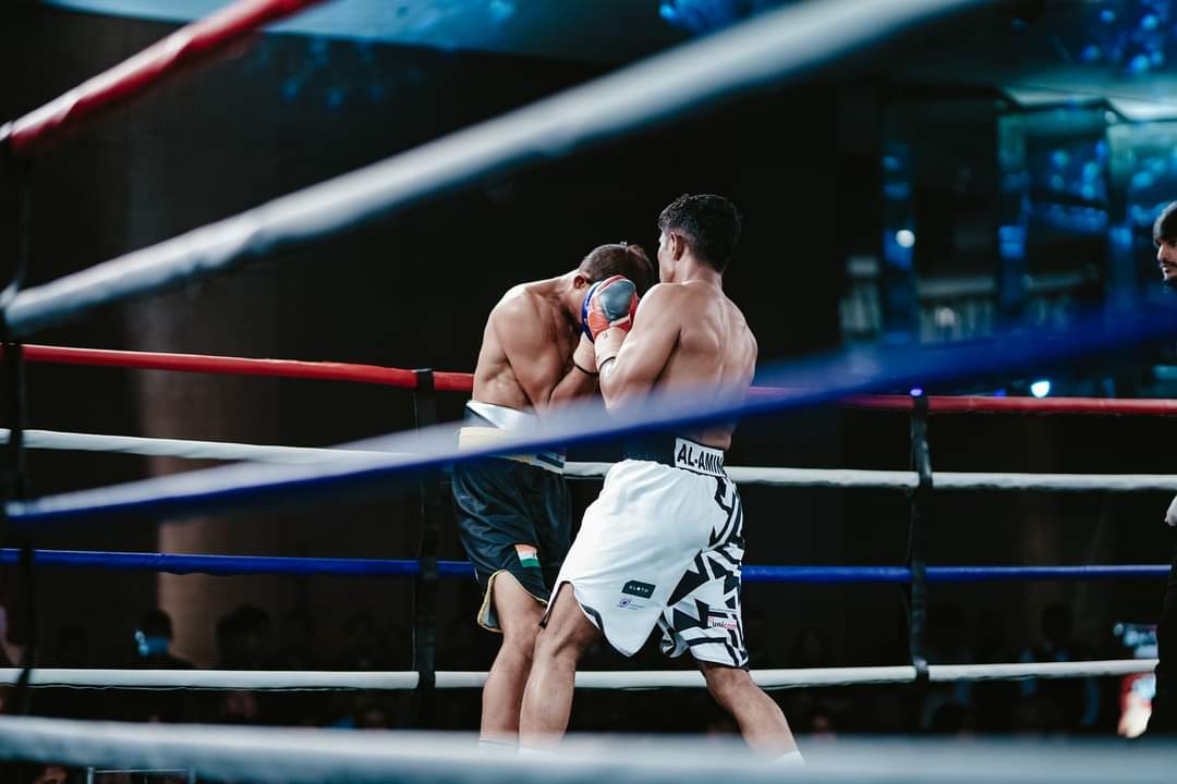 Al-Amin in a clinch with his opponent