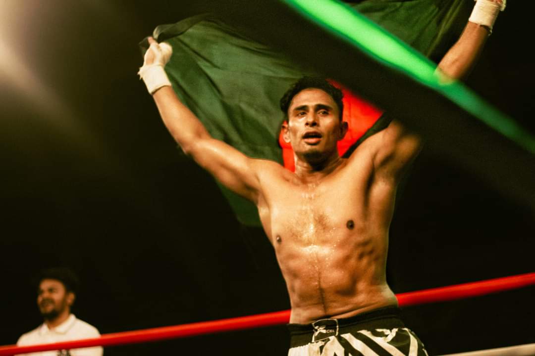 Al-Amin holding the Bangladesh flag above his head in the ring