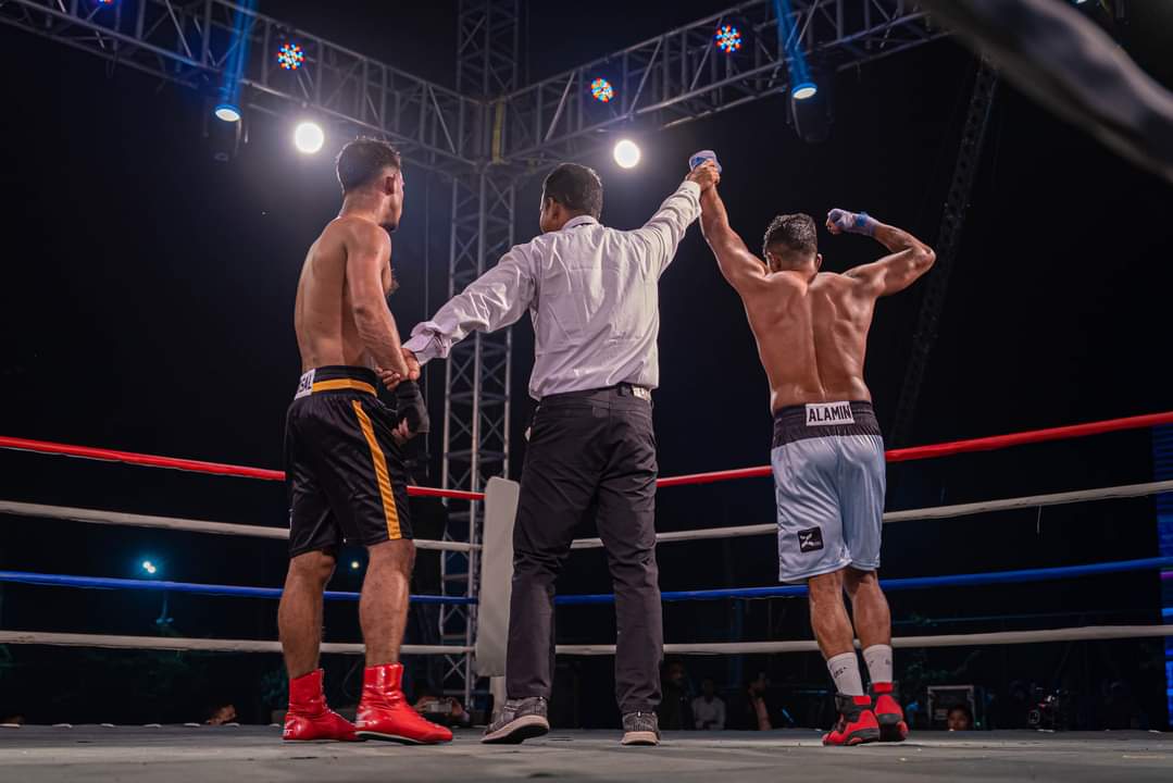 The referee between Al-Amin and his opponent at the end of a bout