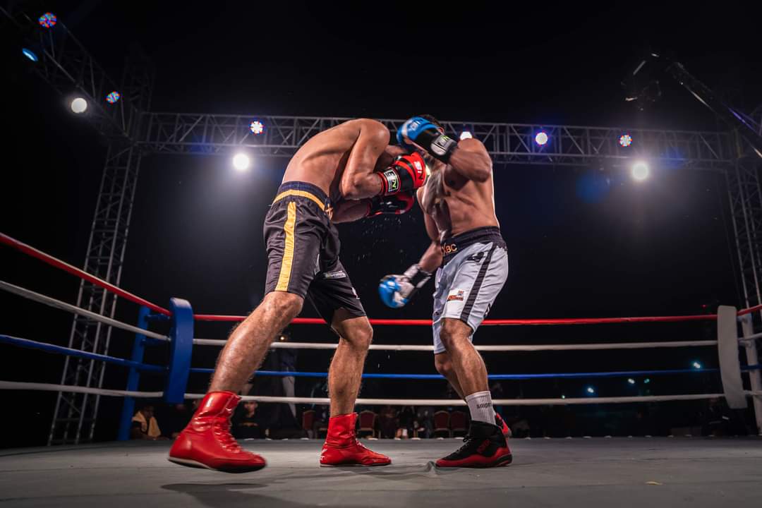Two boxers exchanging under a lighting rig