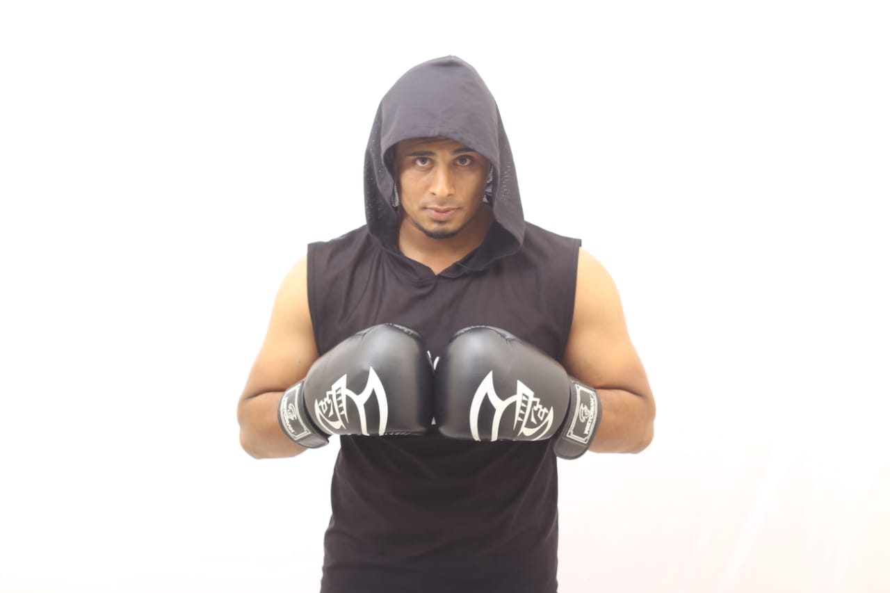 Studio portrait: Al-Amin in a hooded top, gloves together