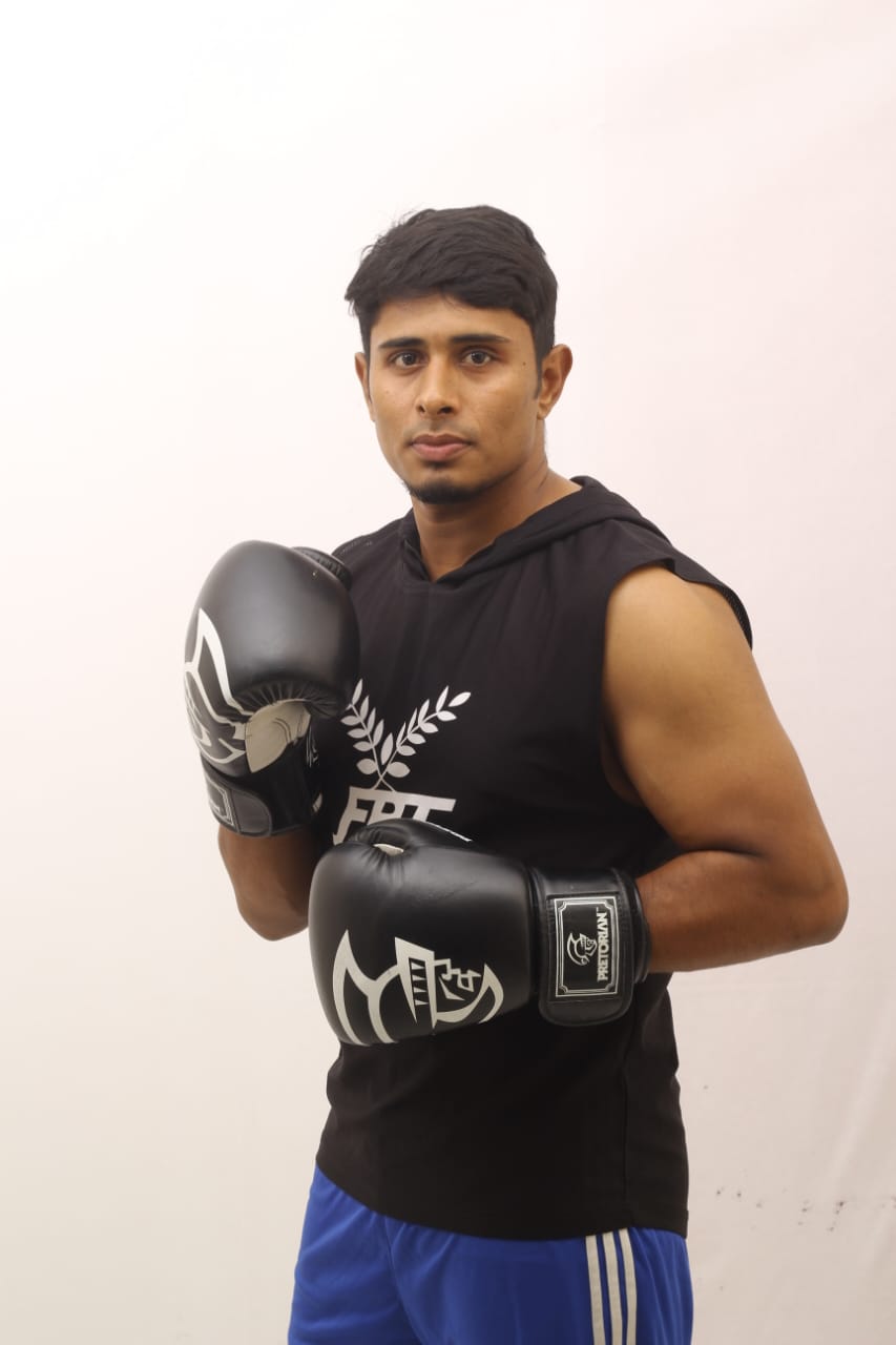 Studio portrait: Al-Amin in a sleeveless top and grey gloves