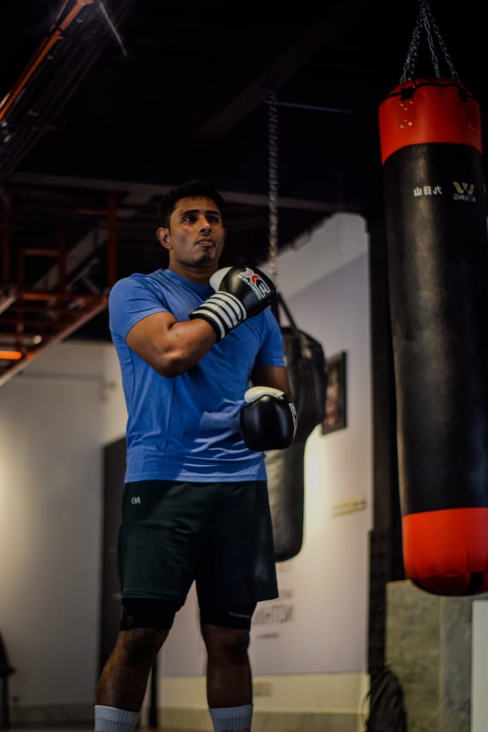 Al-Amin beside a heavy bag in the gym