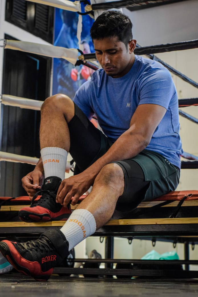 Al-Amin lacing his boxing boots on the ring steps