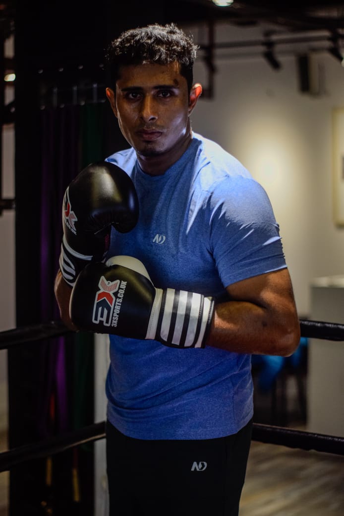 Al-Amin in a blue T-shirt with his gloves up